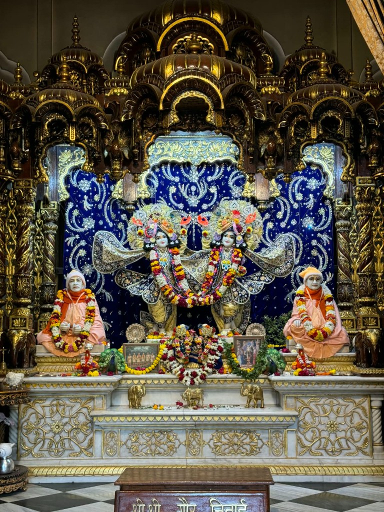 Ornate temple altar with deities and flower garlands