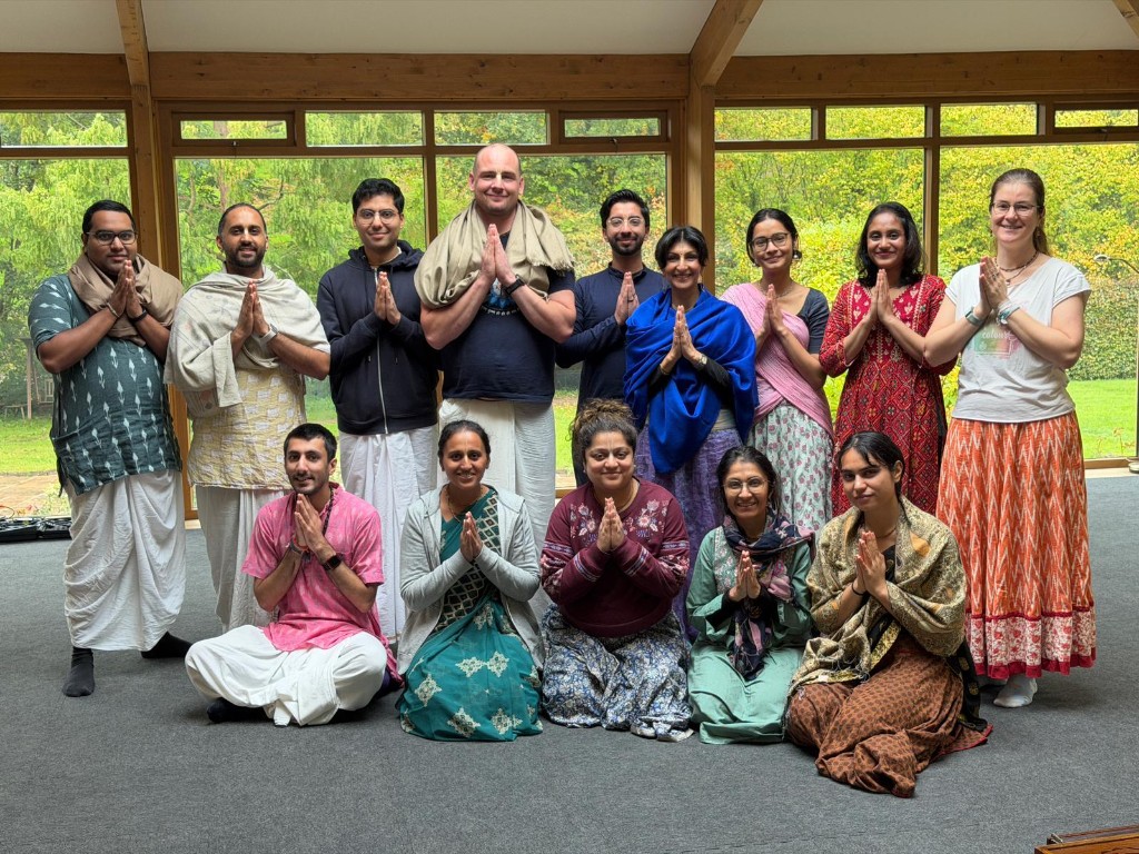 Retreat sangha gathered indoors with hands in prayer
